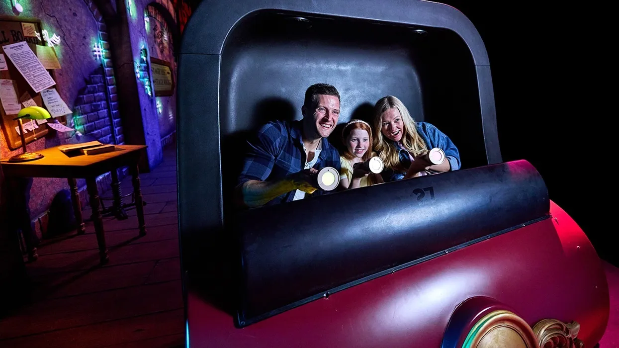 Riders with flashlights on Kings Island’s Phantom Theater: Opening Nightmare
