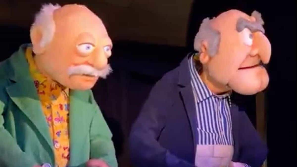 Statler and Waldorf animatronics in suits sitting side by side, mustachioed and grumpy